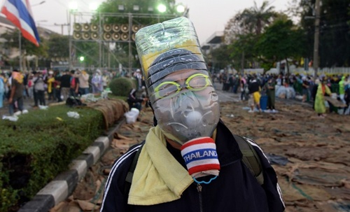 Trong ảnh, một người biểu tình ở Bangkok dùng chai nước, kính bơi