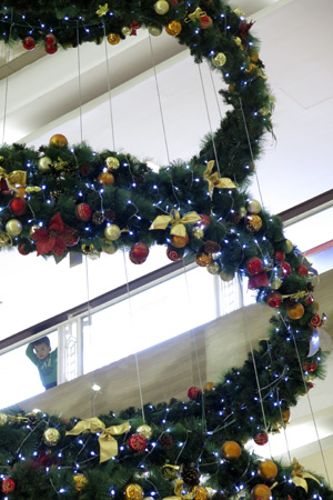 Một chú bé nhìn ngắm cây thông Noel có rất nhiều quả bóng màu sắc sặc sỡ.