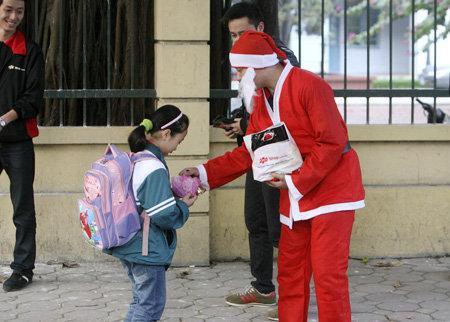 Một em nhỏ ngẫu nhiên được tặng quà từ Ông già Noel khi trên đường đi học về.