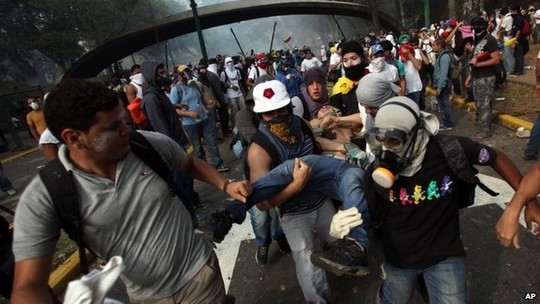 Người biểu tình ở Caracas bị thương sau cuộc đụng độ với cảnh sát. Ảnh: AP