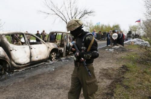 Một chiến binh thân nga đi tuần dọc chốt kiểm tra ở Slaviansk, hiện trường vụ nổ súng làm 5 người thiệt mạng ngày hôm nay. Ảnh: Reuters