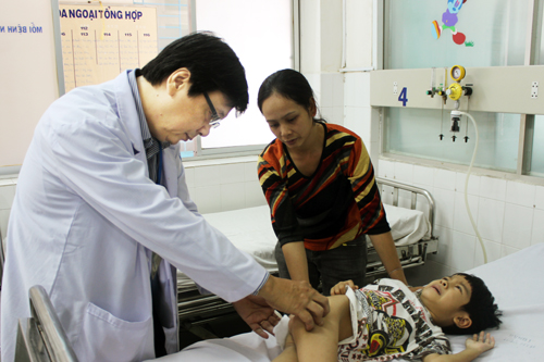 Bác sĩ Đào Trung Hiếu thăm khám kiểm tra vết mổ trước khi bệnh nhi xuất viện. Ảnh: Lê Phương.