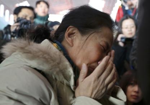 A relative of a passenger onboard Malaysia Airlines flight MH370 cries, surrounded by journalists, at the Beijing Capital International Airport in Beijing March 8, 2014. The Malaysia Airlines flight carrying 227 passengers and 12 crew lost contact with air traffic controllers early on Saturday en route from Kuala Lumpur to Beijing, the airline said in a statement. Flight MH 370, operating a Boeing B777-200 aircraft departed Kuala Lumpur at 12.21 a.m. (1621 GMT Friday) and had been expected to land in the Chinese capital at 6.30 a.m. (2230 GMT) the same day. REUTERS/Kim Kyung-Hoon (CHINA - Tags: TRANSPORT DISASTER)