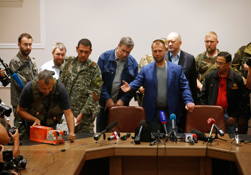 Thủ lĩnh phiến quân Aleksander Borodai (áo vest xanh, ở giữa) bàn giao hai hộp đen cho đại tá Mohamed Sakri, thuộc Hội đồng An ninh Quốc gia Malaysia ở Donetsk, Ukraine hôm nay. Ảnh: Reuters
