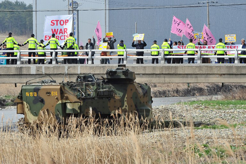 [Caption]South Korean anti-war activists march near an amphibious assault vehicle during a joint landing operation by US and South Korean Marines in Pohang, 270 kms southeast of Seoul, on March 31, 2014 China, the Norths key ally, expressed concern and urged the two Koreas to exercise restraint.In November 2010, North Korea shelled Yeonpyeong island just south of the sea boundary, killing four people and triggering concerns of a full-scale conflict In Washington, White House spokesman Jonathan Lalley called North Koreas actions dangerous and provocative and said they would further aggravate tensions in the region