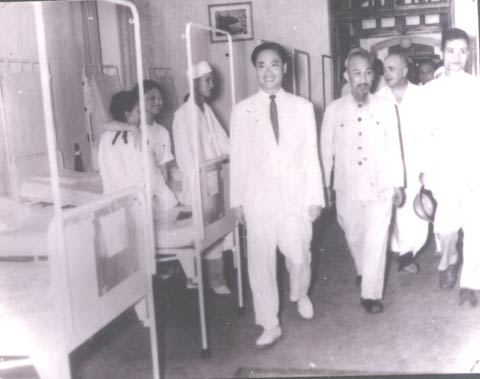GS. Tôn Thất Tùng (người mặc complet trắng bên trái) dẫn Chủ tịch Hồ Chí Minh đi thăm Bệnh viện Việt - Đức sau ngày Hà Nội giải phóng (10/10/1954).
