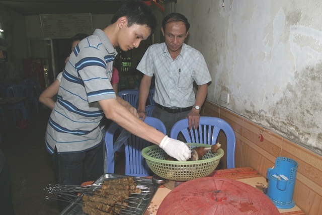 Lấy mẫu thực phẩm tại một cửa hàng ăn để xét nghiệm. Ảnh: Trần Minh