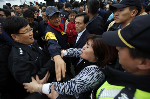 Family members of missing passengers, who were on the South Korean ferry Sewol which sank in the sea off Jindo, jostle with coastguard and police officers as they demand the immediate restart of the search operation, at a port where family members of missing passengers have gathered in Jindo April 17, 2014. South Korean coastguard and navy divers resumed searching on Thursday for about 290 people still missing, many of them students from the same high school, after a ferry capsized in sight of land. REUTERS/Issei Kato (SOUTH KOREA - Tags: DISASTER MARITIME)