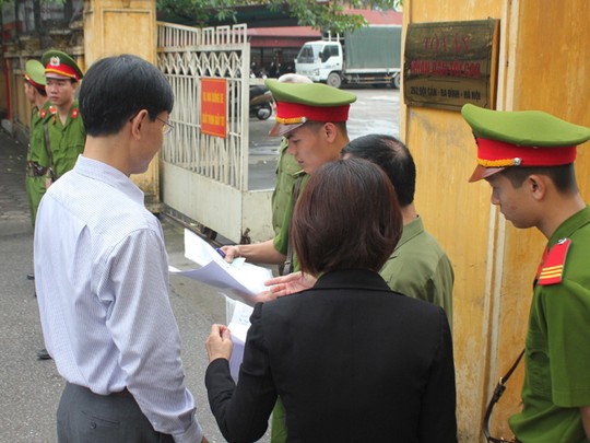 Lực lượng công an bảo vệ phiên tòa kiểm tra giấy tờ những người tới dự phiên tòa