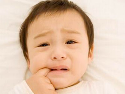 Bắt đầu mọc răng khiến nướu trẻ sưng đau và hay quấy khóc.