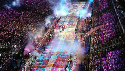 [Caption]Singapores largest batik painting being carried through the F1 Pit Building by volunteers at the Chingay parade last night. The 360m-long banner was painted by 40,000 new immigrants and locally born Singaporeans.