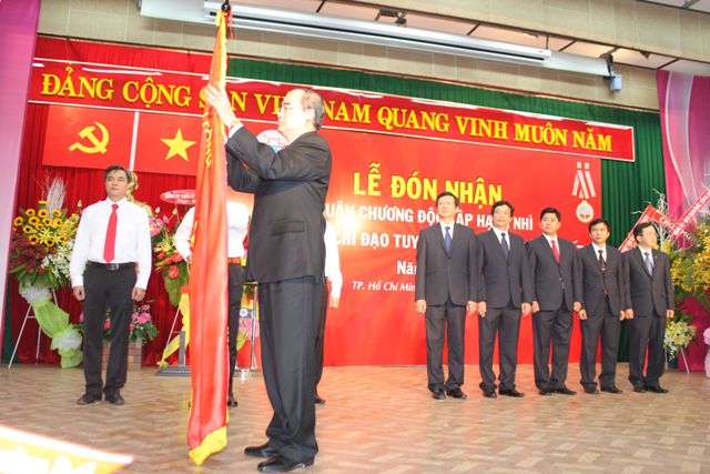 GS.TS Nguyễn Thiện Nhân,  Chủ tịch UBTWMTTQ Việt Nam gắn Huân chương Độc lập hạng Nhì lên cờ truyền thống của Bệnh viện Thống Nhất