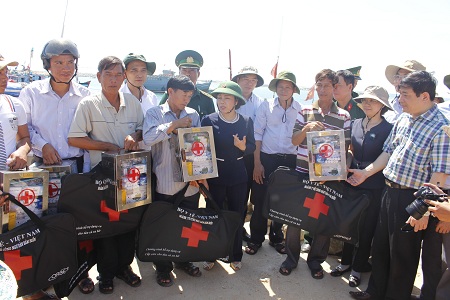 Bộ trưởng Nguyễn Thị Kim Tiến chia sẻ và trao tặng tủ thuốc cho các ngư dân tại âu tàu huyện đảo Lý Sơn.