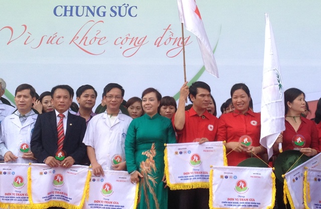 Chủ tịch Ủy ban Trung ương Mặt trận Tổ Quốc Việt Nam Nguyễn Thiện Nhân và Bộ trưởng Bộ Y tế Nguyễn Thị Kim Tiến lên trao cờ lưu niệm cho các đơn vị tham gia.