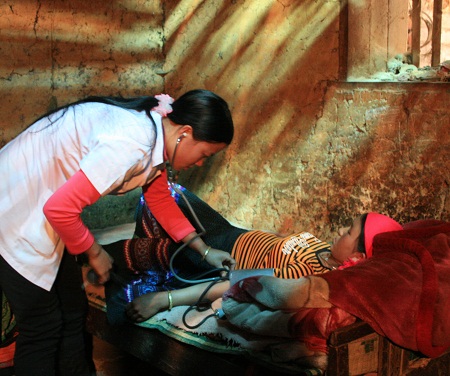 Cô đỡ Vừ Thị Mỵ khám thai định kỳ cho phụ nữ mang thai ở Lũng Cú, Đồng Văn. Ảnh: Tuấn Anh