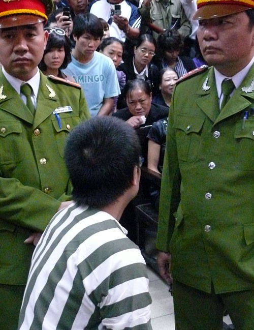 Nguyễn Đức Nghĩa và mẹ (người cầm giấy trắng trên tay) dặn dò nhau tại phiên xét xử. Ảnh: P. Hoa.