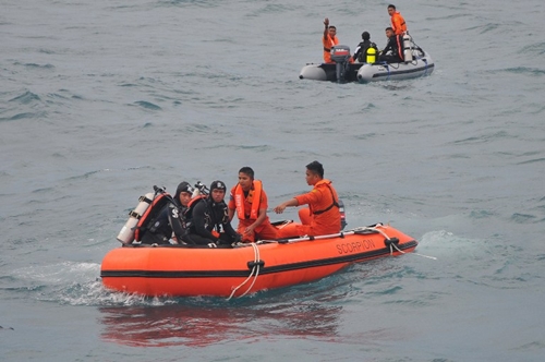 In this photograph taken on February 2, 2015, Indonesian divers and rescue personnel from the National Search and Rescue Agency recover a body from the underwater wreckage of the ill-fated Air Asia flight QZ8501 in Java sea. Indonesian divers on February 2 found another six victims of the AirAsia plane crash, an official said, taking to 84 the number of bodies retrieved since the accident in late December. AFP PHOTO / CHRISTIAN RIBUT