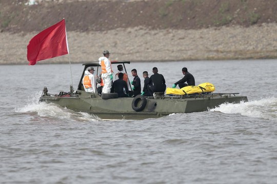 Đội cứu hộ chuyển thi thể nạn nhân vào bờ. Ảnh: Reuters