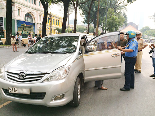 Thanh tra giao thông TP HCM lập biên bản xử phạt hành chính 1 tài xế xe Uber - Ảnh: Hải Phong