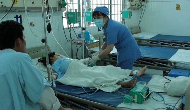 Nữ điều dưỡng Nguyễn Thái Phương Anh đang thăm khám cho bệnh nhi bị sốt xuất huyệt cấp độ nặng.