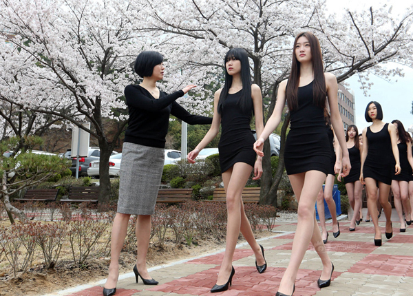 Lớp học catwalk ngoài trời có cô giáo hướng dẫn cách đi đứng cho học sinh.