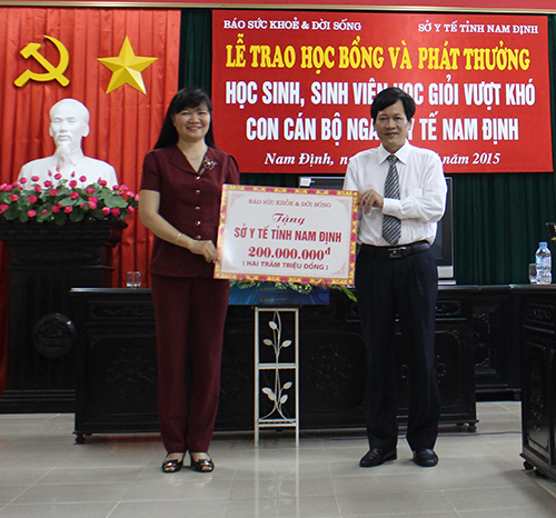 TTƯT.BS. Trần Sĩ Tuấn, Tổng biên tập báo SK&amp;ĐS và DS. Bùi Thị Minh Thu, Giám đốc Sở Y tế Nam Định trao tặng các suất quà cho con em cán bộ ngành y tế tỉnh Nam Định vượt khó vươn lên trong học tập. Ảnh: PV