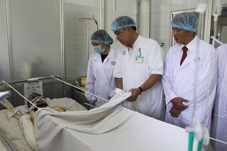 Bộ trưởng Bộ Y tế Nguyễn Thị Kim Tiến thăm điều dưỡng Võ Văn Đấu lúc đang điều trị. Ảnh: Nguyễn Huyền