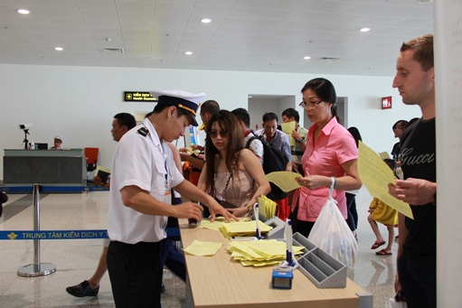 Hành khách khi nhập cảnh được các nhân viên tại TT Y tế kiểm dịch quốc tế hướng dẫn kê khai và đóng dấu xác nhận