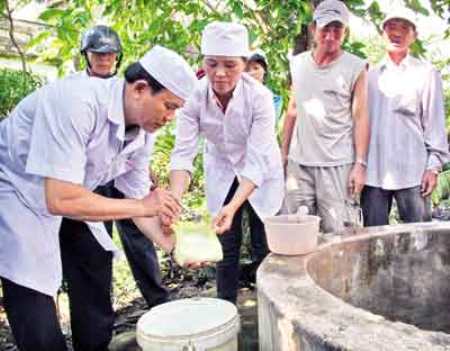 Cán bộ y tế hướng dẫn người dân cách tiêu độc, khử trùng nước sinh hoạt sau mưa bão