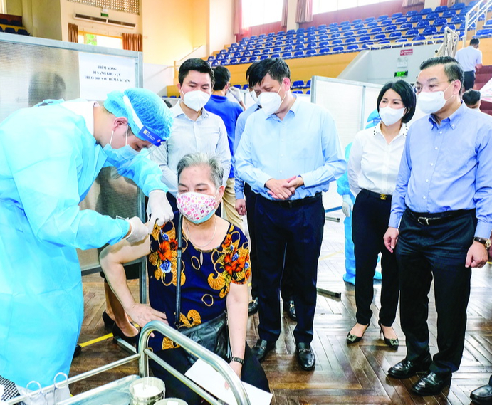 Bộ trưởng Nguyễn Thanh Long (đứng giữa) kiểm tra công tác tiêm chủng vaccine phòng COVID-19 tại Hà Nội. Ảnh: Trần Minh
