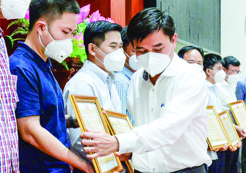 PV Trường Sơn (bên trái) nhận Bằng khen của UBND tỉnh Tiền Giang về thành tích hỗ trợ công tác phòng chống dịch COVID-19 trên địa bàn tỉnh.