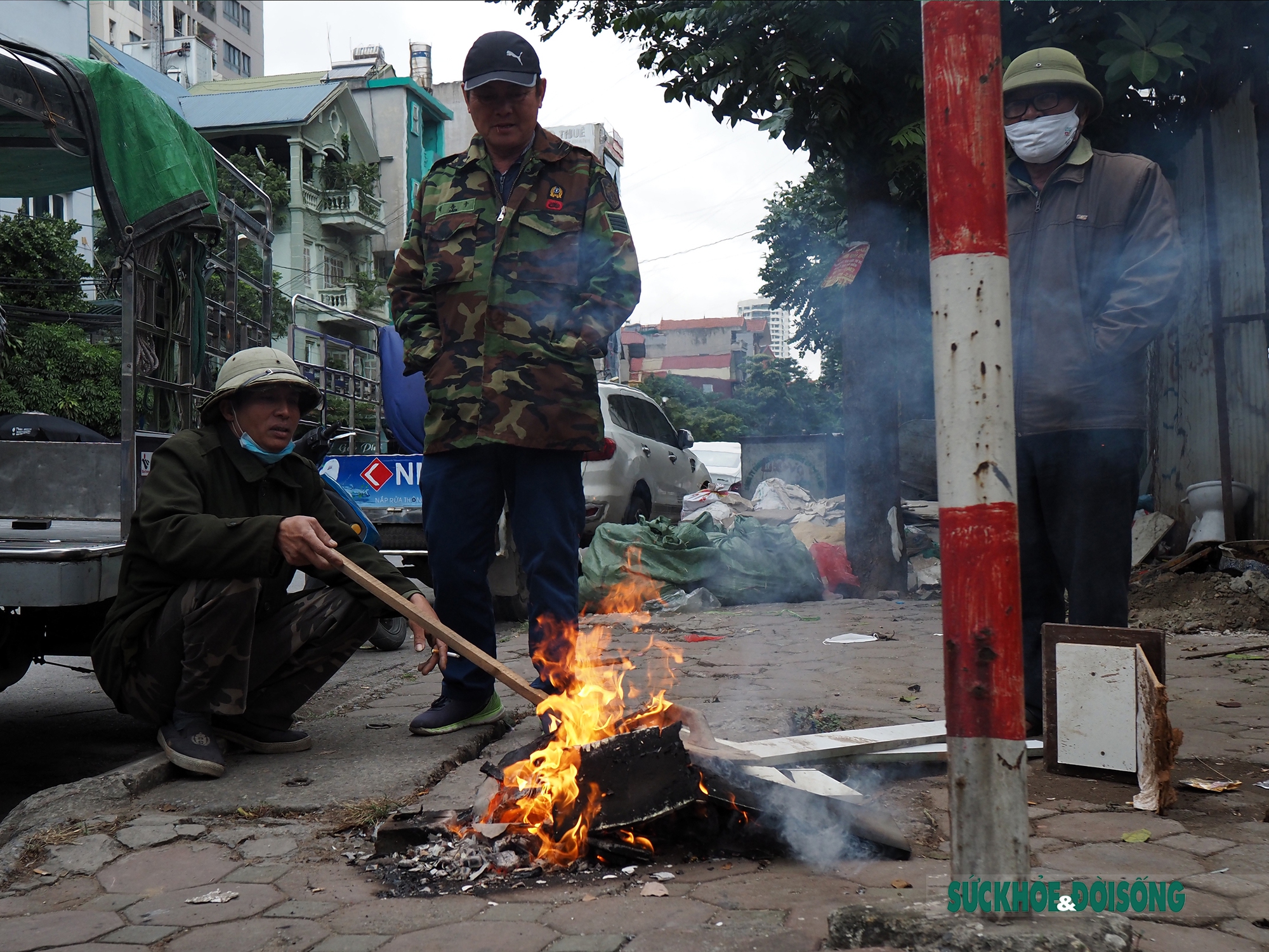 Hà Nội: Người lao động co ro đốt lửa sưởi ấm giữa đường  - Ảnh 3.