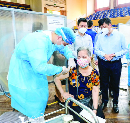 Bộ trưởng Nguyễn Thanh Long (đứng giữa) kiểm tra công tác tiêm chủng vaccine phòng COVID-19 tại Hà Nội. Ảnh: Trần Minh