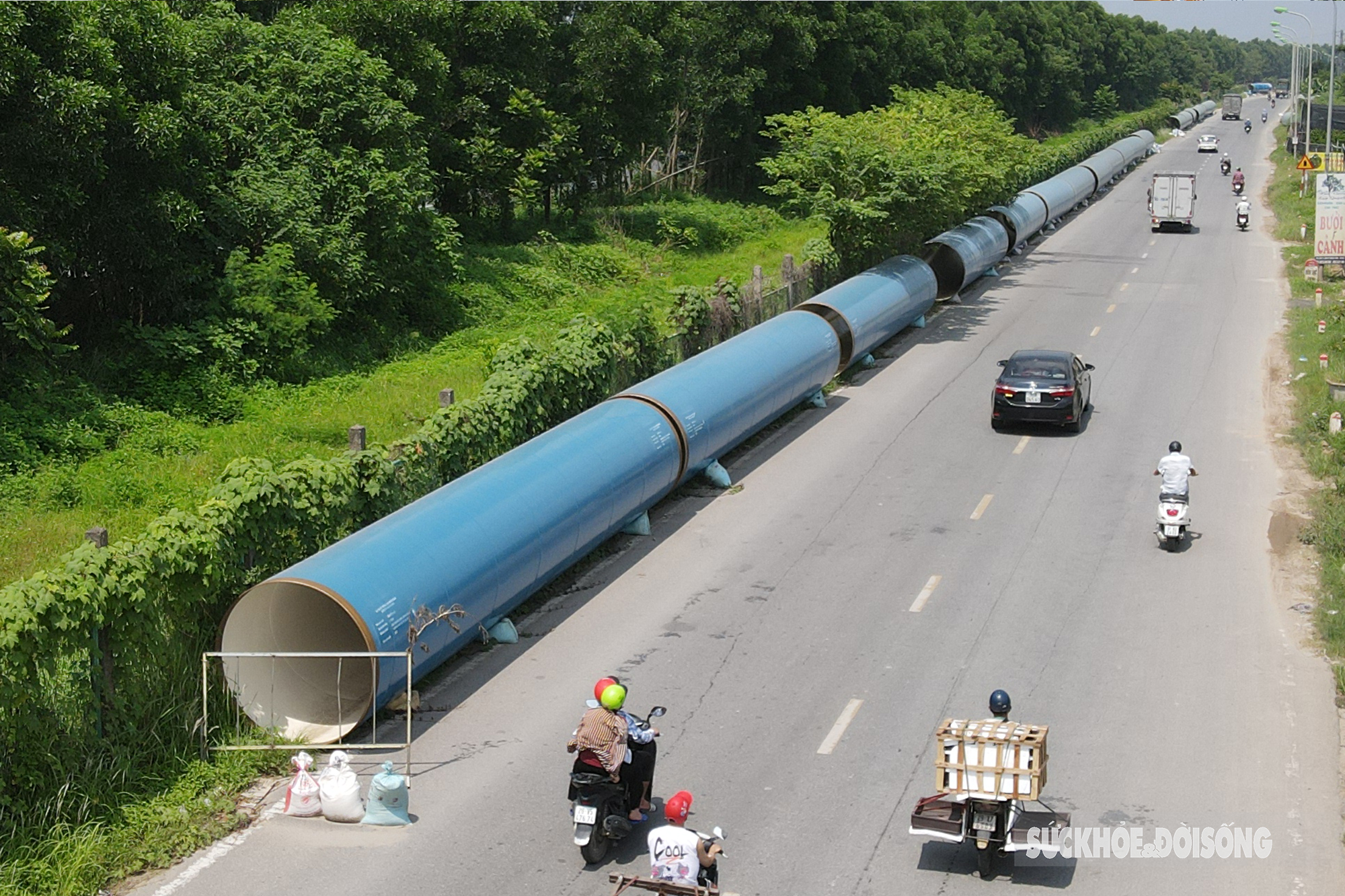 Cận cảnh ống dẫn nước khổng lồ nằm dọc đại lộ Thăng Long đợi ngày lắp đặt - Ảnh 3.