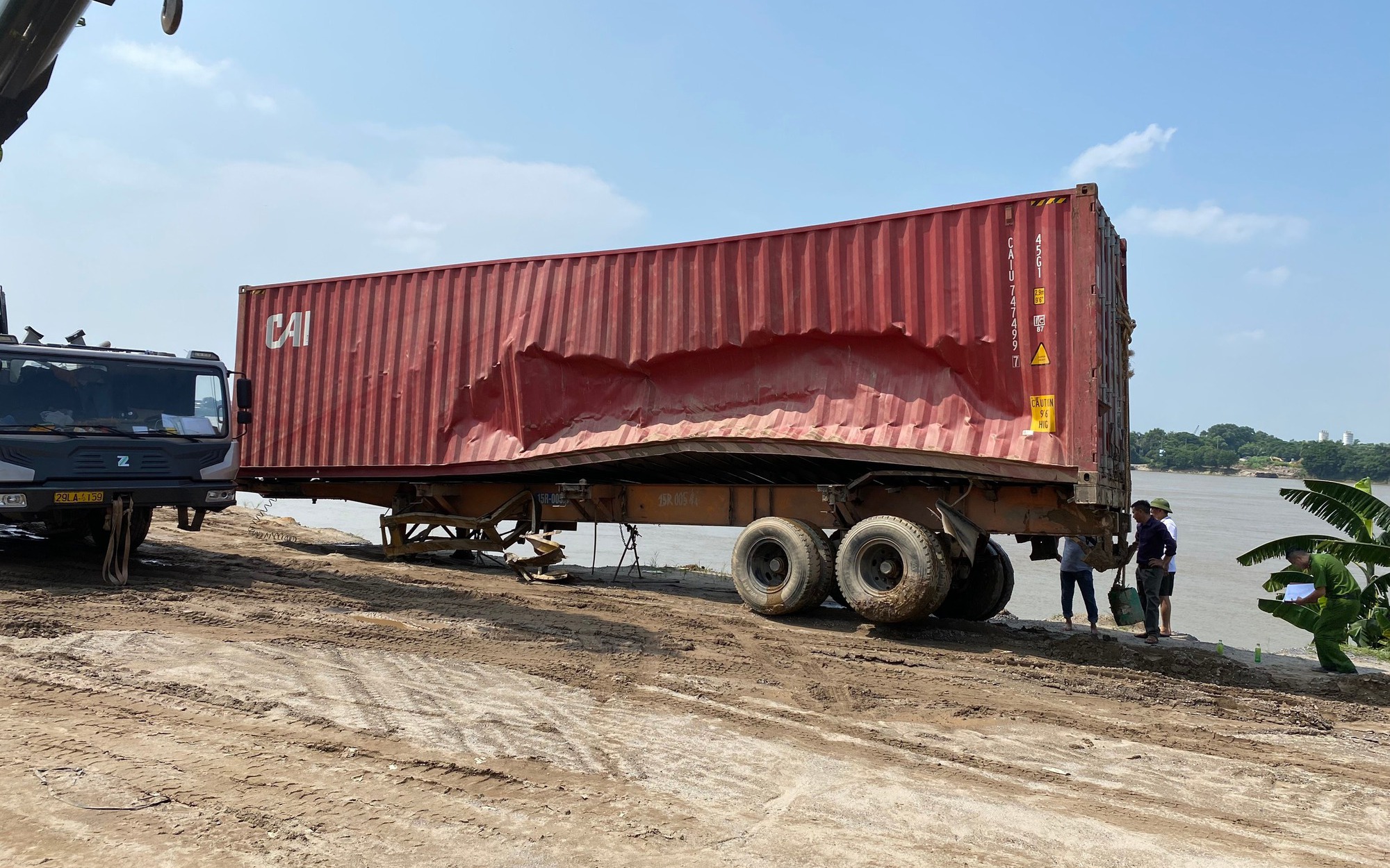 Trục vớt xe container đâm đổ lan can cầu rơi xuống sông Hồng