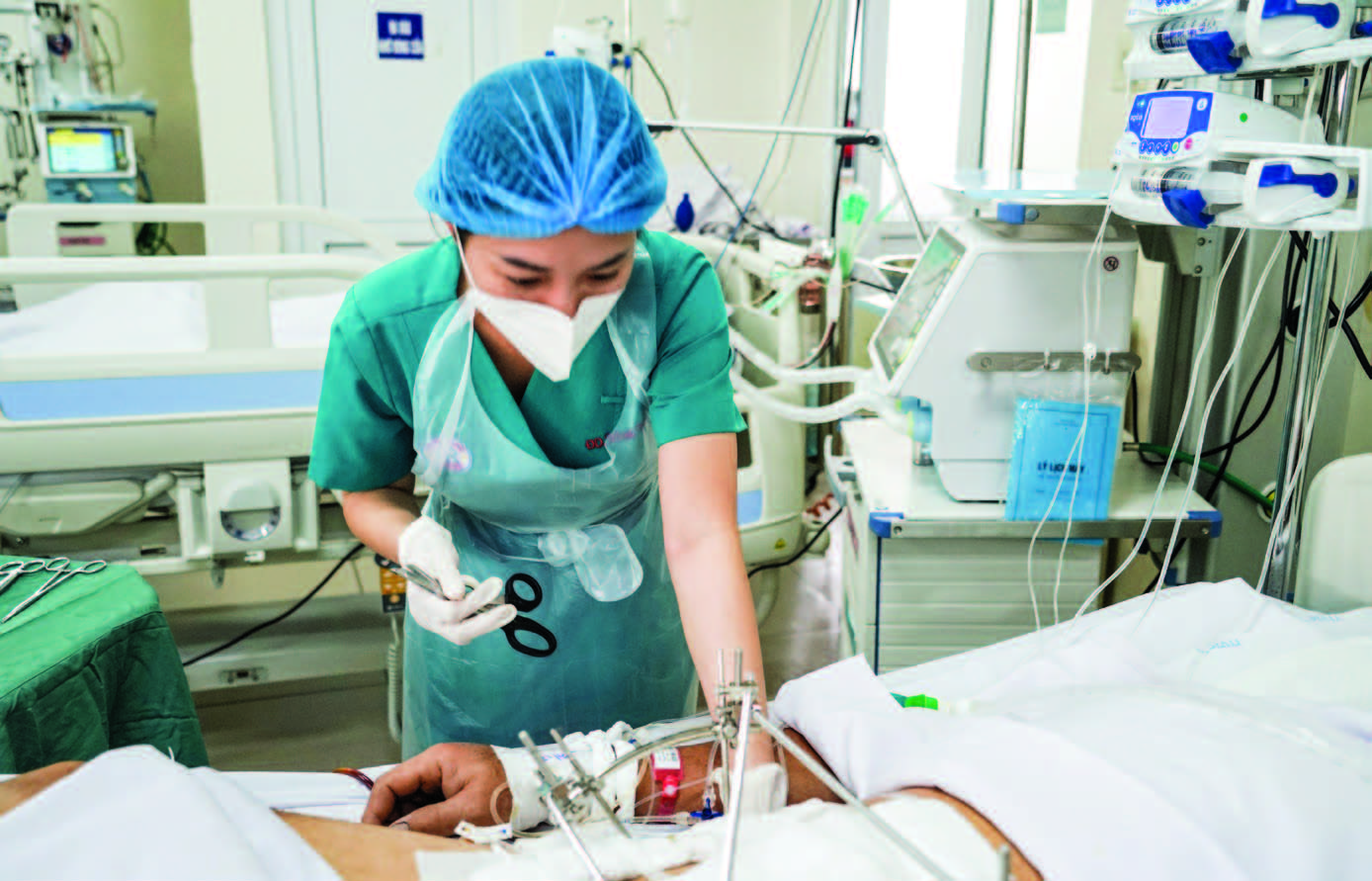 Điều dưỡng Nguyễn Thị Minh Thúy - Khoa Hồi sức Cấp cứu, Bệnh viện Chợ Rẫy chăm sóc bệnh nhân nặng bị tai nạn lao động.