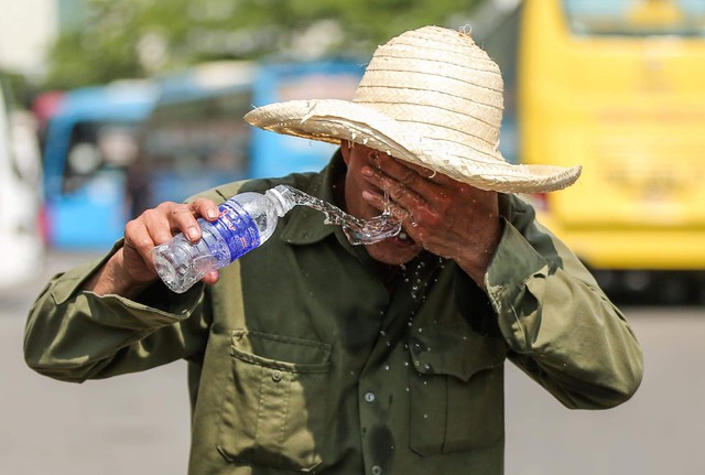 Mặt đường nóng rát hơn 50 độ C, người lao động Hà Nội  “oằn mình&quot; mưu sinh - Ảnh 10.