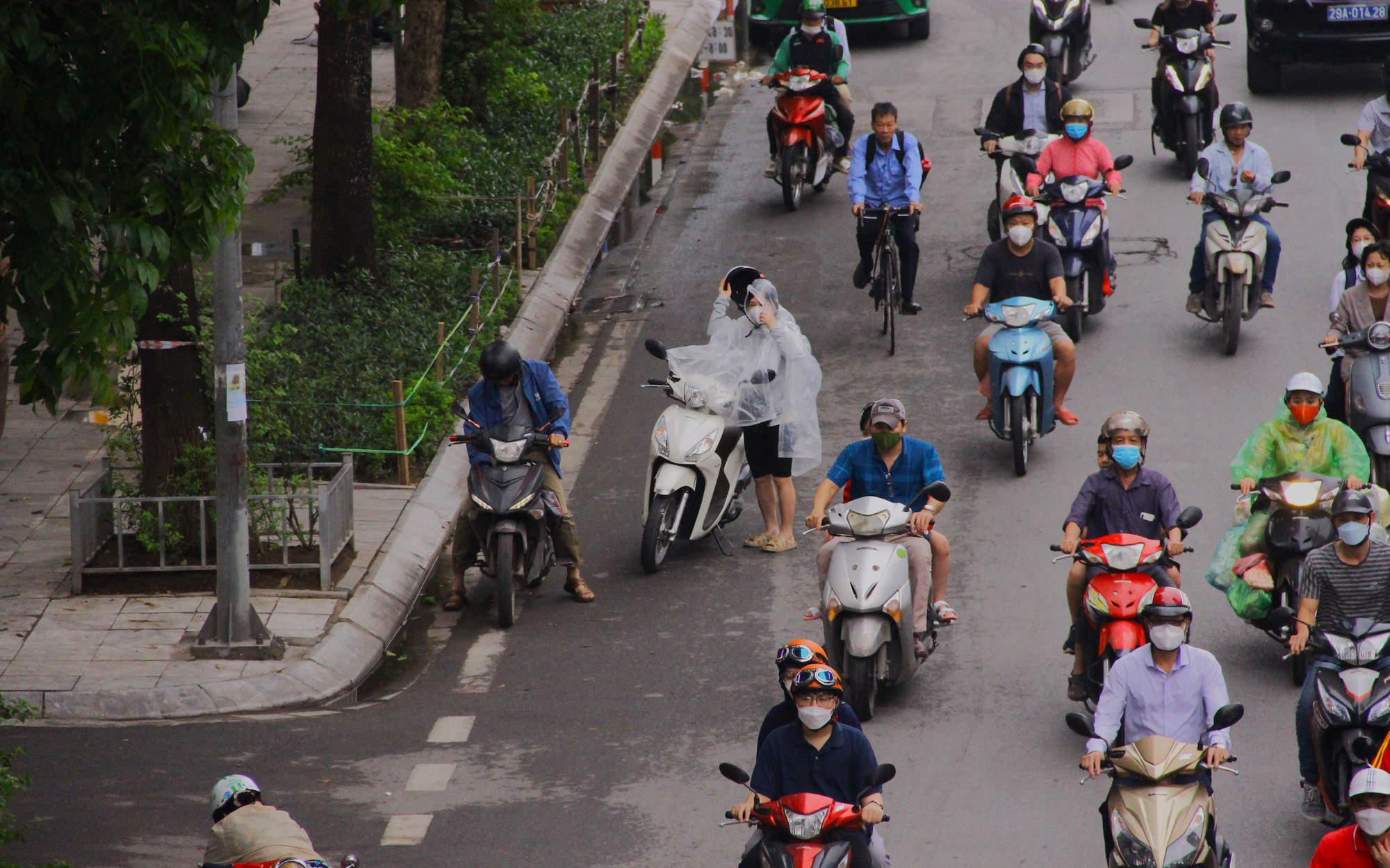 Hà Nội 'hạ nhiệt', người dân ra đường mặc áo mưa thay vì áo chống nắng