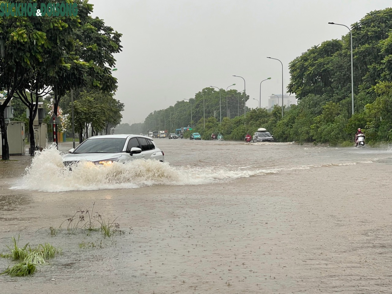 Đường phố Hà Nội ngập sâu sau mưa lớn, người dân chèo thuyền di chuyển - Ảnh 2.