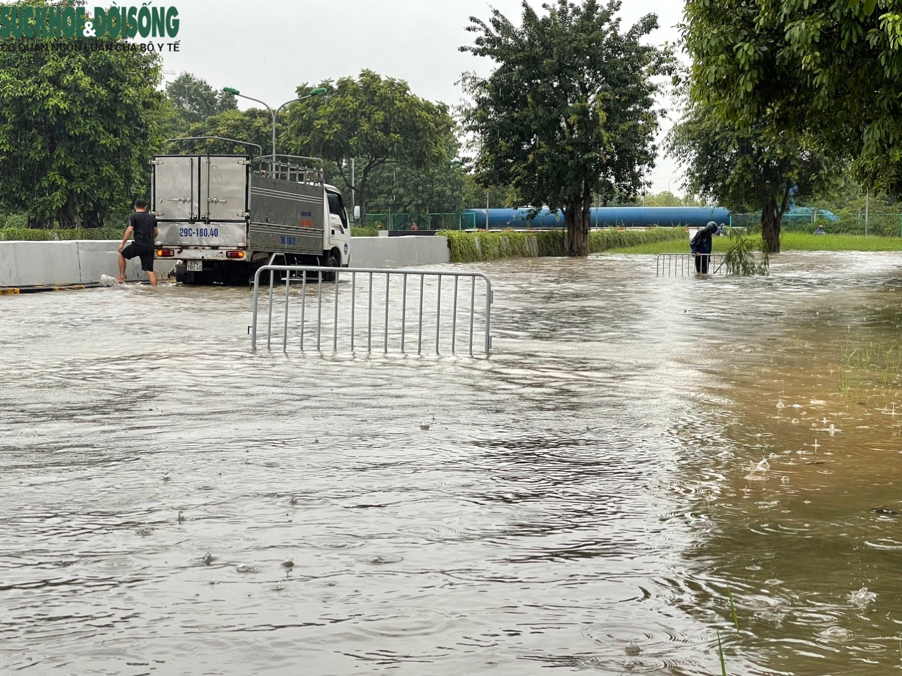 Đường phố Hà Nội ngập sâu sau mưa lớn, người dân chèo thuyền di chuyển - Ảnh 3.