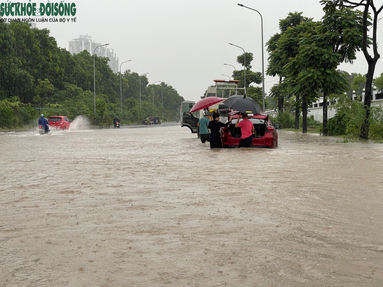 Đường phố Hà Nội ngập sâu sau mưa lớn, người dân chèo thuyền di chuyển - Ảnh 6.