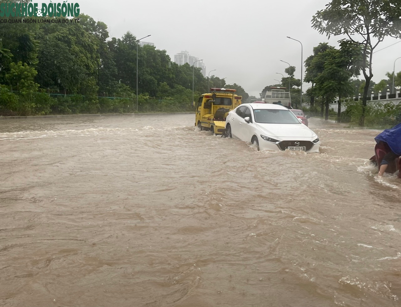 Đường phố Hà Nội ngập sâu sau mưa lớn, người dân chèo thuyền di chuyển - Ảnh 7.