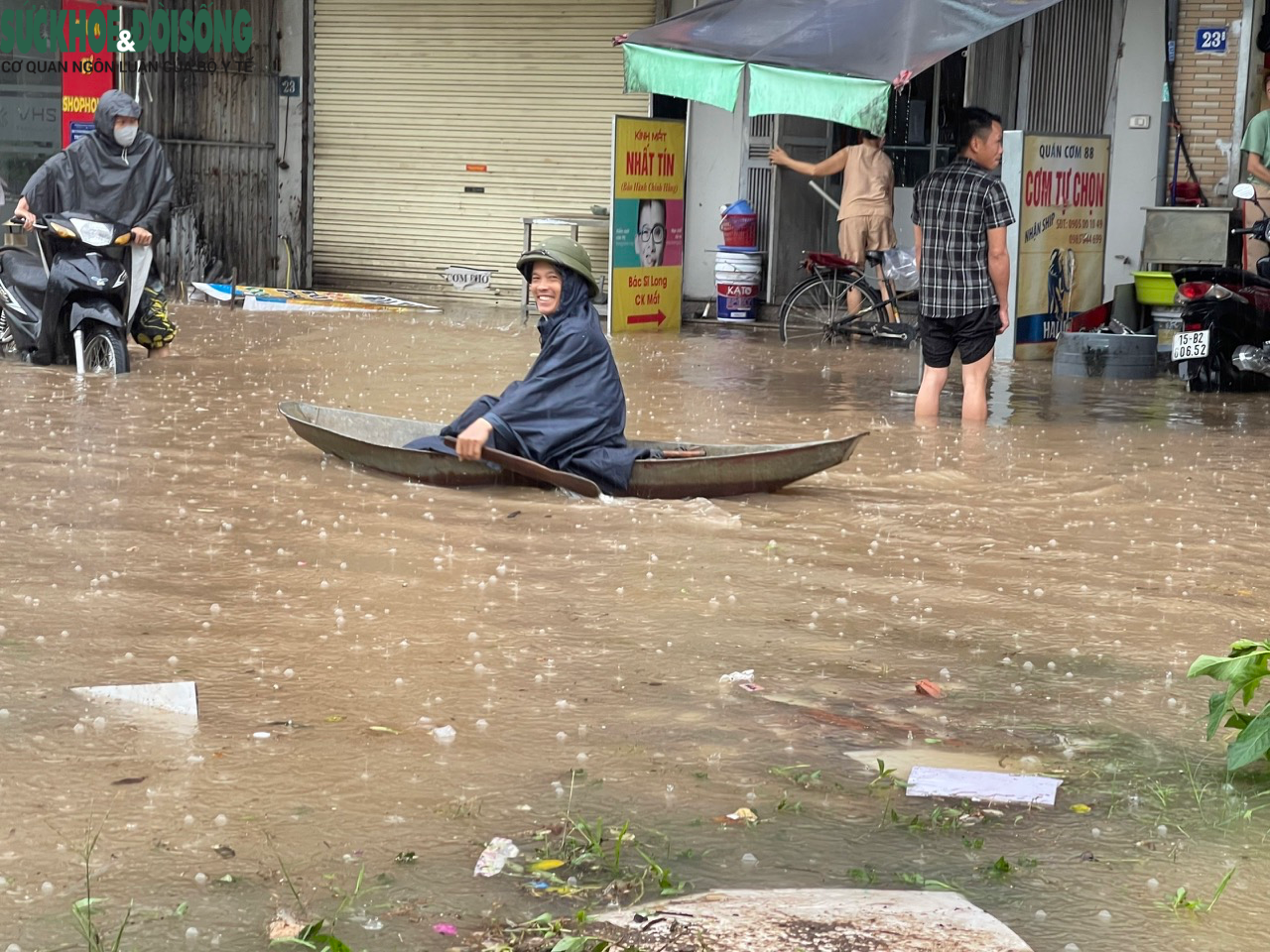 Đường phố Hà Nội ngập sâu sau mưa lớn, người dân chèo thuyền di chuyển - Ảnh 9.