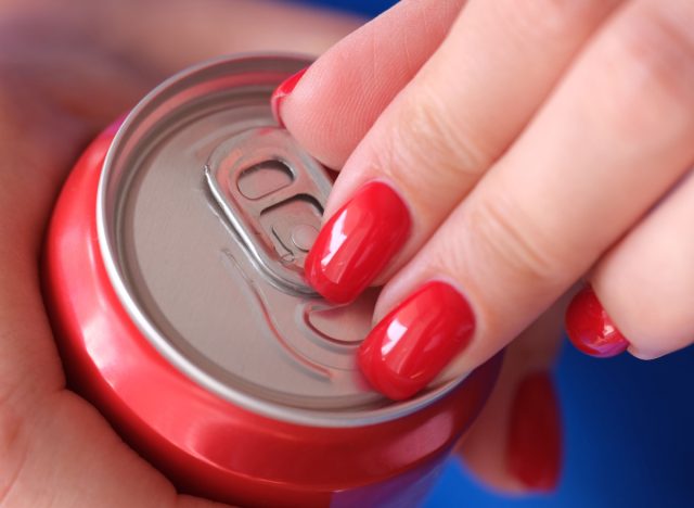 cận cảnh bàn tay của người phụ nữ mở lon soda