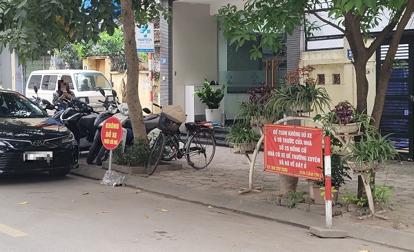 'Cắm mốc' chiếm lòng đường giành chỗ đỗ ô tô có vi phạm pháp luật không?- Ảnh 2.