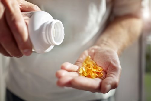 Chai viên dầu cá omega 3 rót vào tay