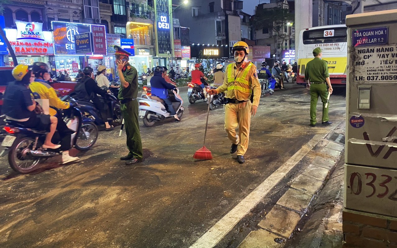 Xe buýt tràn dầu giữa đường, CSGT rải cát tránh người dân 