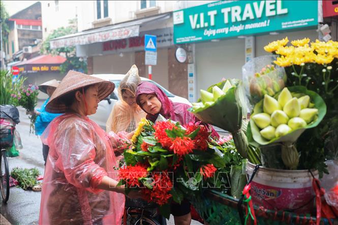 Người dân Hà Nội đội mưa đi mua sắm trong Tết Đoan Ngọ- Ảnh 1.