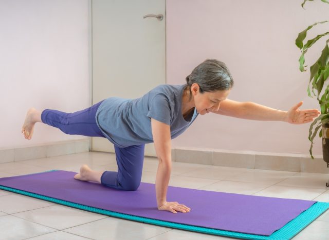 người phụ nữ trưởng thành thực hiện các bài tập yoga giữ thăng bằng, khái niệm về lời khuyên cho phụ nữ để ngăn ngừa mất cơ bắp