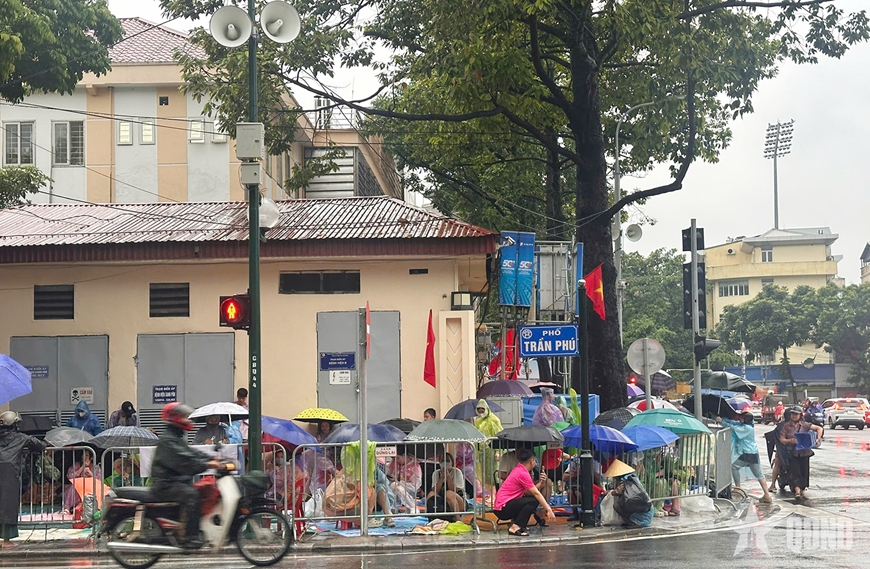 Dù trời mưa, người dân trải bạt giữ chỗ chờ xem Lễ sơ duyệt diễu binh, diễu hành A80- Ảnh 2. Dù trời mưa, người dân trải bạt giữ chỗ chờ xem Lễ sơ duyệt diễu binh, diễu hành A80- Ảnh 2.